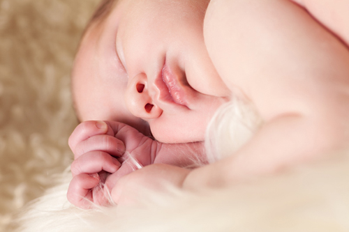 Fotostudio Babys Düsseldorf: Nahaufnahme eines schlafenden Babys. Kamera ist auf gleicher Höhe. 